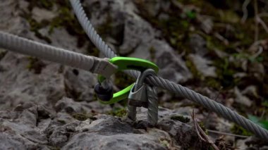 Orta yaşlı bir adam güneşli bir sonbahar gününde ferrata / klettersteig üzerinden kayaya tırmanıyor.
