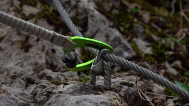 Orta yaşlı bir adam güneşli bir sonbahar gününde ferrata / klettersteig üzerinden kayaya tırmanıyor.