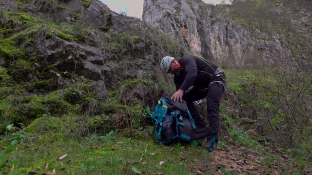 晴れた秋の日に岩の上に登り リンゴを食べた中年の男 Ferrata Klettersteg — ストック動画