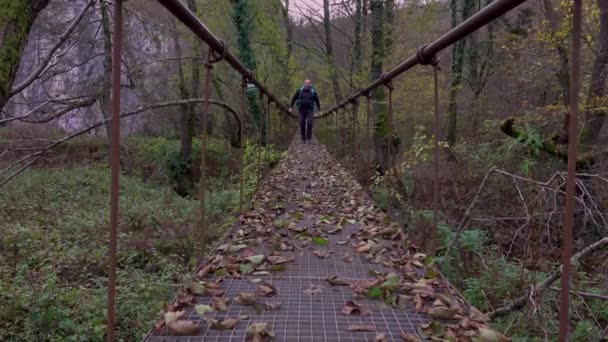 Człowiek Kręcący Się Moście Linowym Nad Rzeką Jesienią — Wideo stockowe