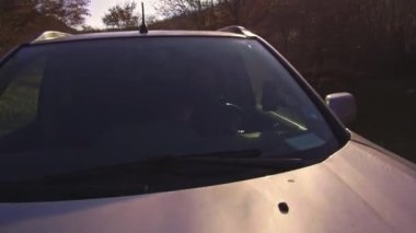 Bir adam ormanın içinde off-road araba sürüyor. Arabanın dışından bak.