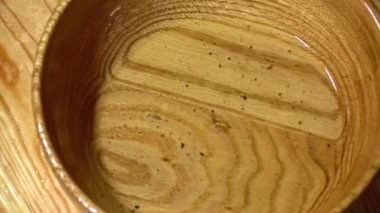 Siyah zeytin ve kiraz domatesleri ahşap bir kaseye düşüyor. Yakın çekim, yavaş çekim.