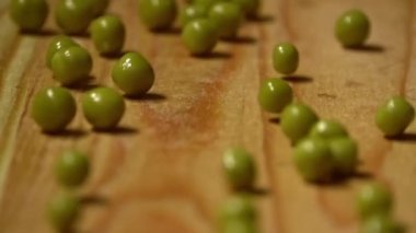 Tahta üzerinde yeşil bezelyeler, yakın plan. Yavaş çekim.