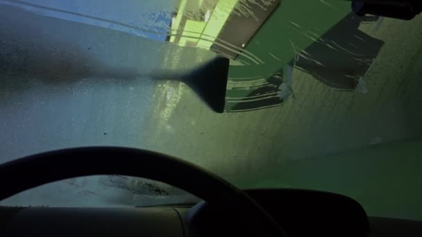 雪嵐の後の雪と氷から車のフロントガラスを掃除する男 — ストック動画
