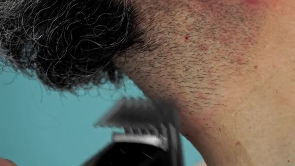 中年男人 卷曲的头发 光秃秃的躯干 在经历了漫长的冒险之后 又用电动修整器修整着他那乱糟糟的长胡子 — 图库视频影像