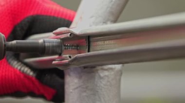 Elle çalışan işçi binaların direnç yapısını birleştiriyor ve vida tabancasıyla çalışıyor.