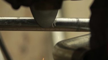 Profesyonel tamirci torna torna tezgahında metal bir boru kesiyor. Adam torna tezgahıyla bir metal parçası kesiyor.