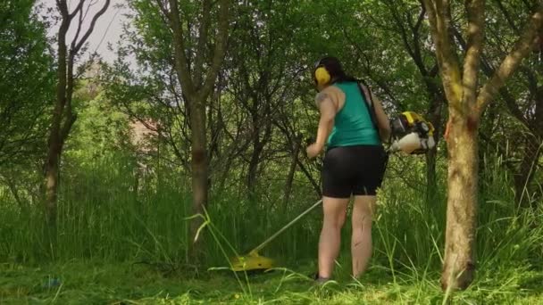 Bahçede Uzun Çimenleri Bir Fırçayla Kesen Kadın — Stok video
