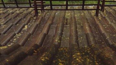 Heavy rain pouring on a building roof.