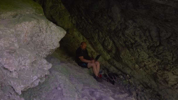 Serin Bir Mağarada Çalışan Dizüstü Bilgisayarı Olan Bir Yürüyüşçü Sıcak — Stok video