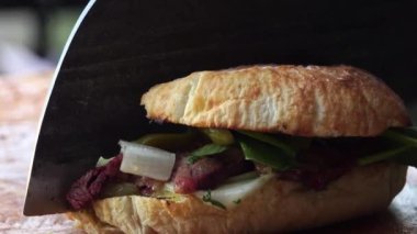 Adam öğle yemeği hazırlar, ahşap kesme tahtasının üstünde sağlıklı ızgara ekmek sandviçi sunar.