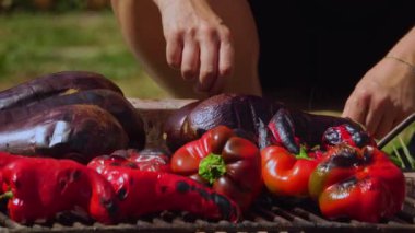 Geleneksel Rumen zakuskası yapmak için atılmış önemli bir adım olan odun ateşinin üzerinde ızgara yapan sebzelerin kırsal bir açık hava sahnesi. Ateşte kızartılmış sebzeler derin, dumanlı tatlar sunuyor, bu sevgili ev yapımı sebzenin özünü yakalıyor..