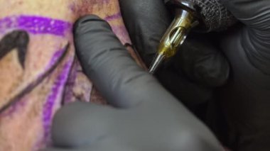 Bu büyüleyici yakın çekim ile dövmenin karmaşık dünyasına dalın. Sanatçının ellerine ve dövme makinesine odaklanan video, her bir eşsiz tasarımın yaratıcılığını ve hassasiyetini yakalıyor..