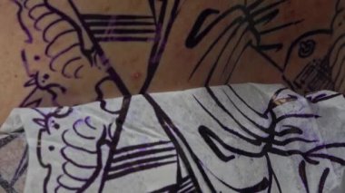 Bu büyüleyici yakın çekim ile dövmenin karmaşık dünyasına dalın. Sanatçının ellerine ve dövme makinesine odaklanan video, her bir eşsiz tasarımın yaratıcılığını ve hassasiyetini yakalıyor..