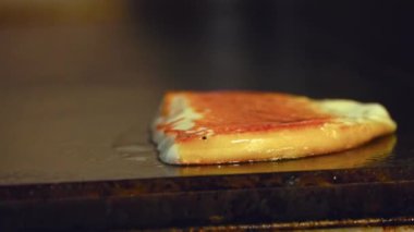 Bir dilim kremalı peynirin sıcak ızgarada cızırdamasını ve erimesini izleyin. Hamburgeriniz için lezzetli bir malzemeye dönüşüyor. Altın sarısı kenarları ve pürüzsüz, erimiş merkezi bu peyniri karşı konulmaz yapıyor..