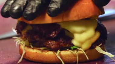 Ağzını sulandıran bir hamburgerin son adımlarını izleyin, sulu köfte, taze sebzeler ve erimiş peynirden, üzerine altın tost ekmeği koymaya kadar. Her bileşen mükemmel dengeyi yaratmak için dikkatlice yerleştirilmiştir..
