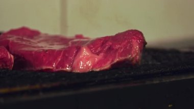 Bu videoda ızgarada sulu bir bifteğin cızırtısını deneyin. Etin mükemmelliğe doğru kavruluşunu izleyin. Zengin lezzetlere kilitlenişini ve mükemmel kabuğu oluşturuşunu izleyin..