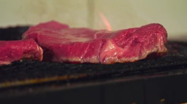 Bu videoda ızgarada sulu bir bifteğin cızırtısını deneyin. Etin mükemmelliğe doğru kavruluşunu izleyin. Zengin lezzetlere kilitlenişini ve mükemmel kabuğu oluşturuşunu izleyin..