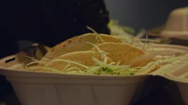 Izgara sığır eti ve taze salatanın dikkatlice paketlenip bu yakın çekim videoda teslim edilmeye hazır hale getirilmesini izleyin. Yumuşak, sulu sığır eti, yumuşak ekmeğe sarılmış, canlı, gevrek bir salata ile eşleştirilir..