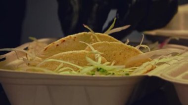 Izgara sığır eti ve taze salatanın dikkatlice paketlenip bu yakın çekim videoda teslim edilmeye hazır hale getirilmesini izleyin. Yumuşak, sulu sığır eti, yumuşak ekmeğe sarılmış, canlı, gevrek bir salata ile eşleştirilir..