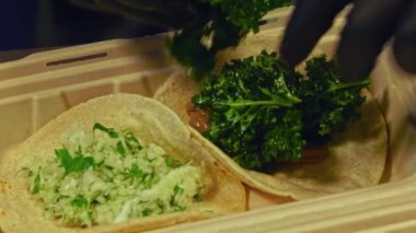 Izgara sığır eti ve taze salatanın dikkatlice paketlenip bu yakın çekim videoda teslim edilmeye hazır hale getirilmesini izleyin. Yumuşak, sulu sığır eti, yumuşak ekmeğe sarılmış, canlı, gevrek bir salata ile eşleştirilir..