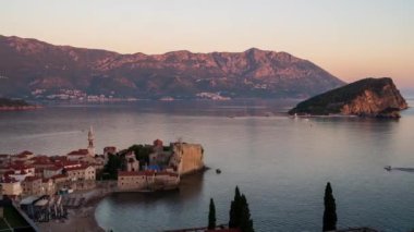 Budva Eski kenti ve Karadağ 'ın tekneli marinası üzerinde gün doğumunun inanılmaz bir videosu. Geceden güne hiperaktifleşir.