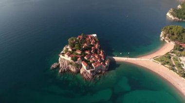 Aerial video of the famous tourist location Sveti Stefan island and picturesque Adriatic coastline near the city of Budva, Montenegro.