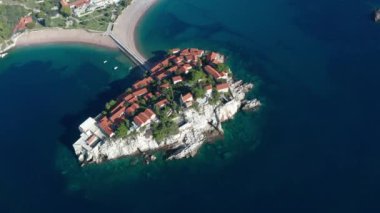 Aerial video of the famous tourist location Sveti Stefan island and picturesque Adriatic coastline near the city of Budva, Montenegro.