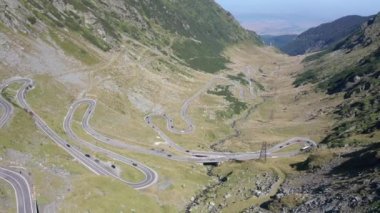 Amazing aerial video of the northern part of the famous serpentine Transfagarasan mountain road between Transylvania and Muntenia with many vehicles slowly coming around the bends, Romania