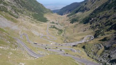 Amazing aerial video of the northern part of the famous serpentine Transfagarasan mountain road between Transylvania and Muntenia with many vehicles slowly coming around the bends, Romania