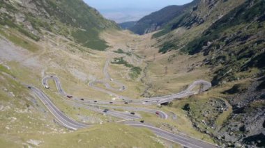 Amazing aerial video of the northern part of the famous serpentine Transfagarasan mountain road between Transylvania and Muntenia with many vehicles slowly coming around the bends, Romania