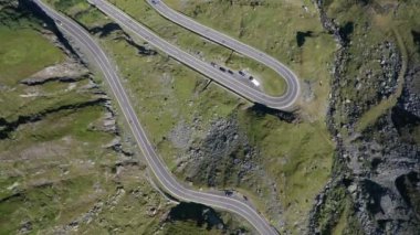 Amazing aerial video of the northern part of the famous serpentine Transfagarasan mountain road between Transylvania and Muntenia with many vehicles slowly coming around the bends, Romania