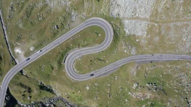 Amazing aerial video of the northern part of the famous serpentine Transfagarasan mountain road between Transylvania and Muntenia with many vehicles slowly coming around the bends, Romania