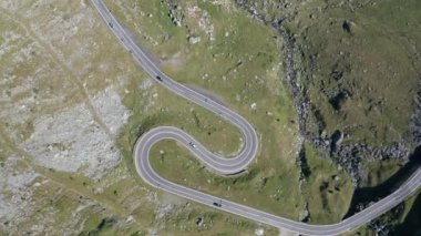 Amazing aerial video of the northern part of the famous serpentine Transfagarasan mountain road between Transylvania and Muntenia with many vehicles slowly coming around the bends, Romania