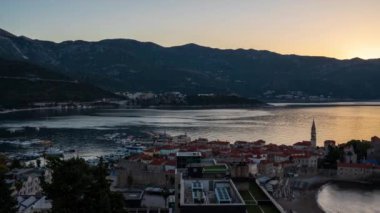 Amazing time lapse video of a sunrise over Budva Old town and marina with boats, Montenegro. Hyper lapse from night to day.