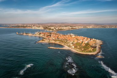 Bulgaristan 'ın Karadeniz kıyısındaki antik bir kasaba olan Nessebar' ın havadan görünüşü, kırmızı çatılı evler ve yatlı rıhtımlar ve turkuaz suların ortasında küçük tekneler.