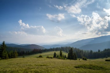 Ağaçlarla kaplı yamaçların üzerinde güzel bulutlar ve Bulgaristan 'daki Rodop dağları ile muhteşem panoramik manzara.