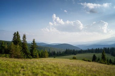 Ağaçlarla kaplı yamaçların üzerinde güzel bulutlar ve Bulgaristan 'daki Rodop dağları ile muhteşem panoramik manzara.