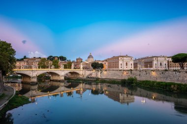 Beautiful colorful sunrise view of Rome Skyline with the famous Vatican Saint Peter Basilica and Saint Angelo Bridge above Tiber River in Rome, Italy. 	