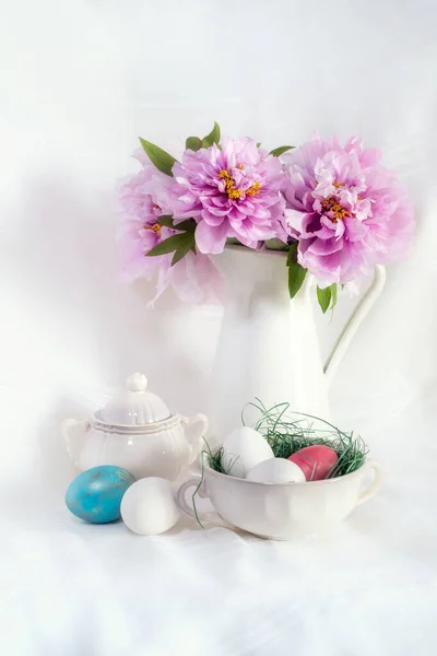 复活节依然存在 花瓶里有华丽的粉色牡丹 白色背景上有彩蛋的古董瓷碗 — 图库照片