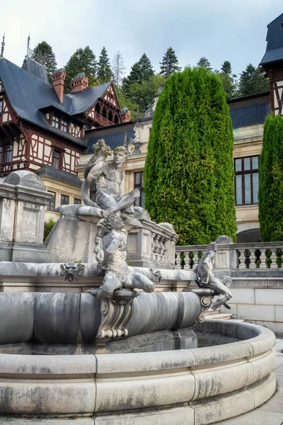stock image Sculptures and plants in the well-tended garden in front of the beautiful facade of Peles Castle near Sinaia, Romania.
