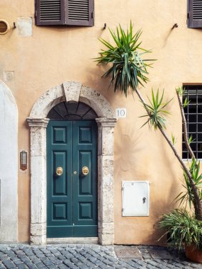 Trastevere, Roma, İtalya 'da metal kapı kollarıyla dekore edilmiş eski bir klasik kapı.