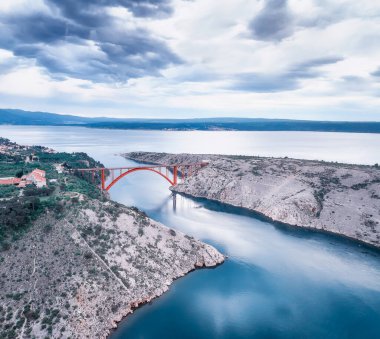 Hırvatistan 'ın Zadar kenti yakınlarındaki bir güverte kemeri olan Maslenica köprüsü ile hava panoramik manzarası güzel bulutlar ve canlı denizlerle dolu