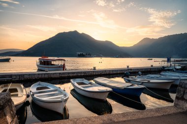 Kotor Körfezi 'ndeki pitoresk Perast kasabasının gezinti güvertesinden panoramik manzara, Karadağ' ın batımında rıhtımda teknelerle.