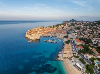 Eski kenti, dar taş caddeleri ve kırmızı çatıları olan binaları, Adriyatik deniz kıyısında tekneleri olan marinaları olan manzaralı Dubrovnik kentinin hava panoramik manzarası, Hırvatistan.