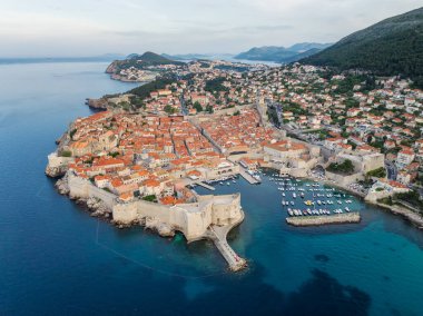 Eski kenti, dar taş caddeleri ve kırmızı çatıları olan binaları, Adriyatik deniz kıyısında tekneleri olan marinaları olan manzaralı Dubrovnik kentinin hava panoramik manzarası, Hırvatistan.