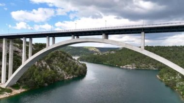 Hırvatistan 'ın Adriyatik kıyısındaki İbenik kasabası yakınlarındaki güzel bir güverte kemer köprüsünün hava panoramik videosu.