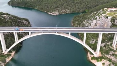 Hırvatistan 'ın Adriyatik kıyısındaki Shibenik kasabası yakınlarındaki güzel bir güverte kemer köprüsünün hava panoramik videosu.