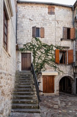 Karadağ 'ın eski Kotor kentindeki antik taş binalarla dolambaçlı dar sokaklar boyunca sabah yürüyüşü