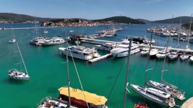 Hırvatistan 'ın orta Dalmaçya bölgesindeki Rogoznica turkuaz körfez kasabası ve marinasının hava panoramik videosu